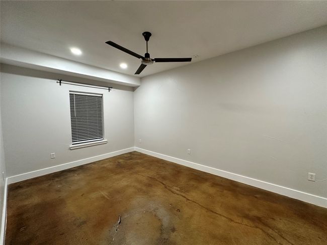 Bedroom 1 featuring scorned concrete flooring, ceiling fan, flooring, recessed LED lightings. | Image 8