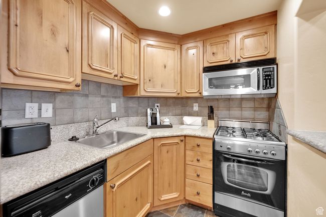 Kitchen featuring light countertops, a sink, stainless steel appliances, and light brown cabinetry | Image 18