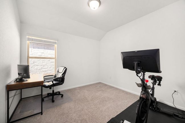 Carpeted office space featuring baseboards and lofted ceiling | Image 28