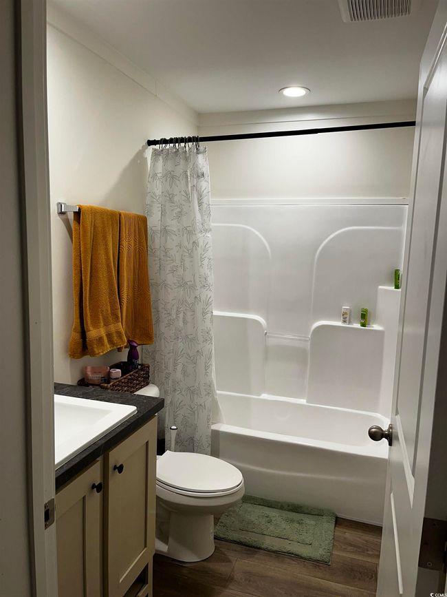 Full bath with vanity, shower / tub combo, wood finished floors, and recessed lighting | Image 10