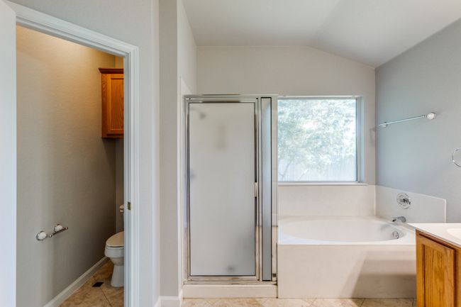 Master Full Bathroom with a stall shower, a garden tub, vanity, tile patterned floors, and lofted ceiling | Image 32
