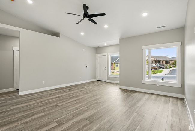 Unfurnished living room featuring wood finished floors, a ceiling fan, baseboards, and recessed lighting | Image 10