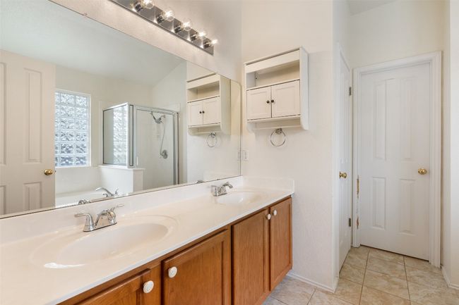 Full bathroom featuring a sink, tile patterned flooring, a stall shower, and double vanity | Image 26