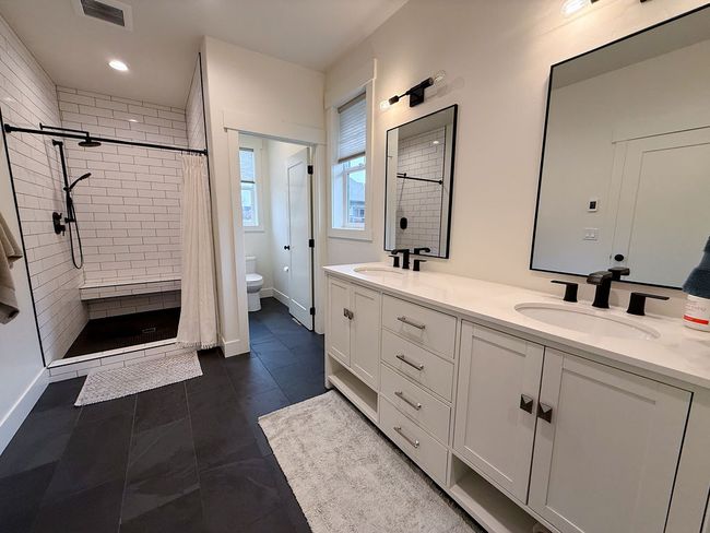 Primary bathroom featuring double sinks, tiled shower and radiant heated floors | Image 16