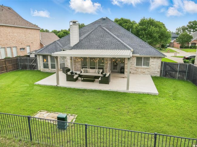 Rear view of house featuring an outdoor living space, a fenced backyard, brick siding, and a shingled roof | Image 28