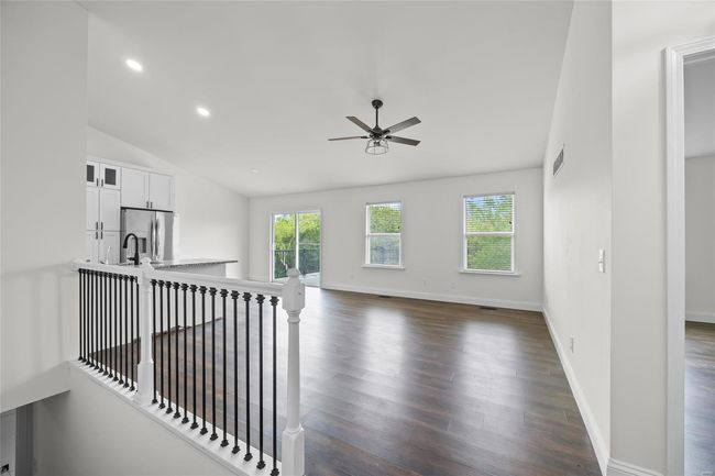 Unfurnished living room with visible vents, a ceiling fan, dark wood finished floors, and a wealth of natural light | Image 18