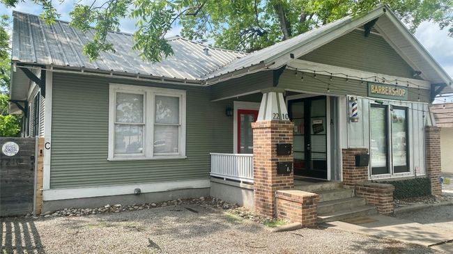 View of front facade with a metal roof and a porch | Image 15
