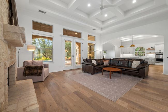Living room featuring arched walkways, a towering ceiling, ceiling fan, light wood finished floors, and recessed lighting | Image 5
