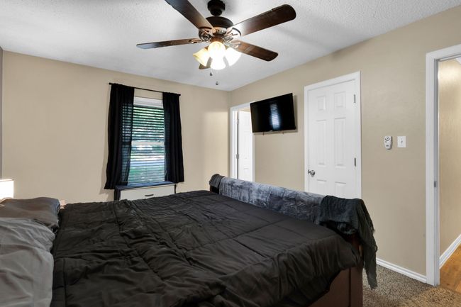 Bedroom featuring ceiling fan, a textured ceiling, and carpet | Image 11