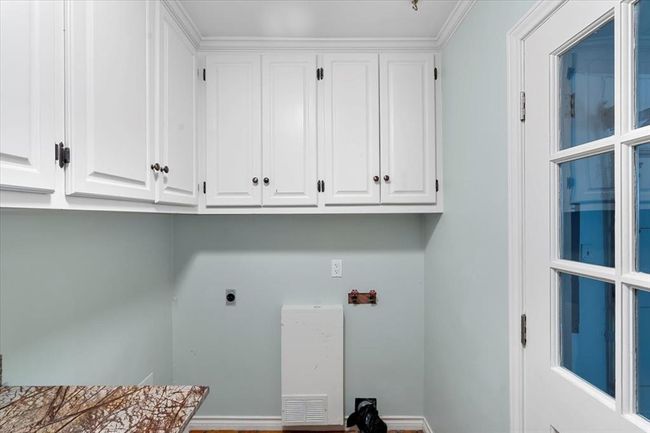 Clothes washing area featuring cabinets, hookup for an electric dryer, and crown molding | Image 36