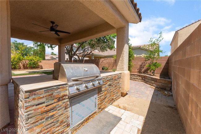 Fenced backyard featuring a ceiling fan and a patio area | Image 49