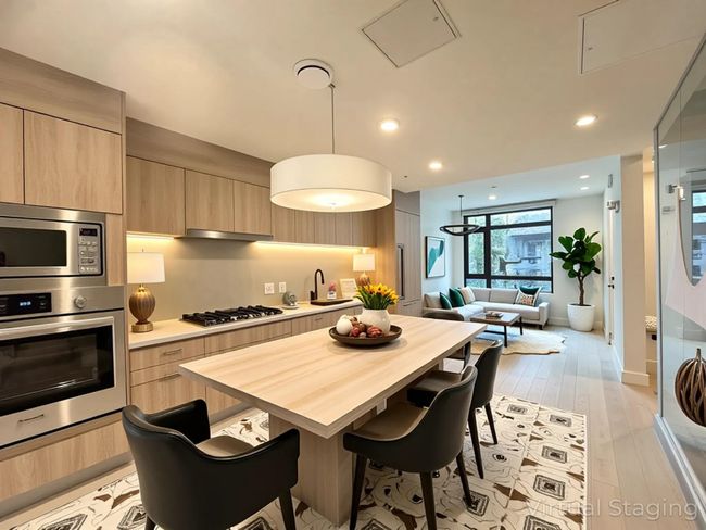 Kitchen with stainless steel appliances, light brown cabinets, modern cabinets, a kitchen bar, and open floor plan | Image 20