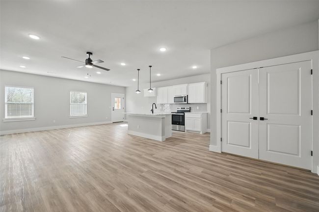 Unfurnished living room featuring recessed lighting, light wood-style flooring, a sink, and a ceiling fan | Image 8