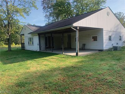 Rear view of property featuring central AC, a patio, and a lawn | Image 2