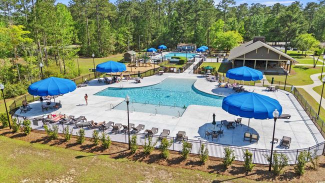 Community pool with view of wooded area and a patio area | Image 27