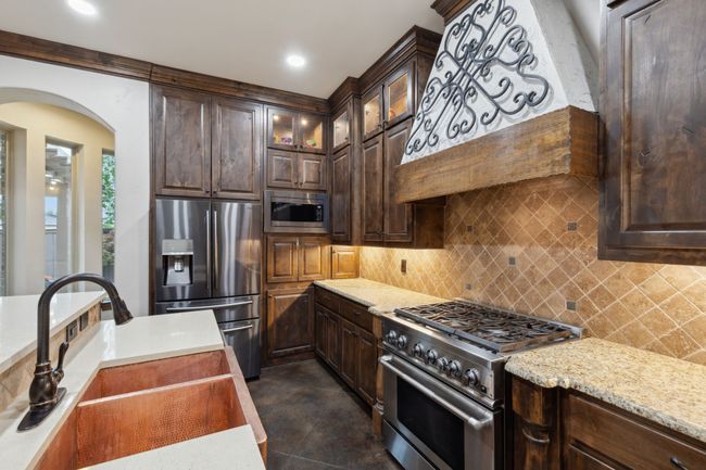 Kitchen with dark brown Knotty Pine custom cabinetry, copper farmhouse dual sink | Image 9