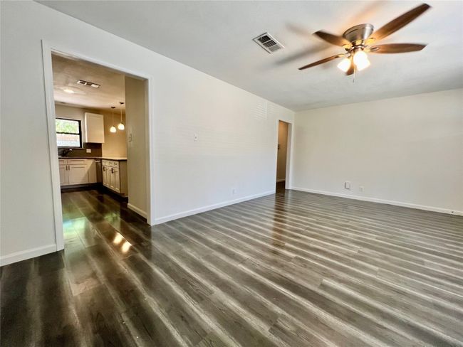 Spare room with a ceiling fan, dark wood-style flooring, and baseboards | Image 6