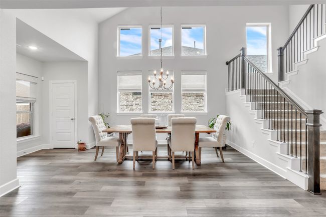 Dining space with an inviting chandelier, hardwood / wood-style floors, and a high ceiling | Image 15