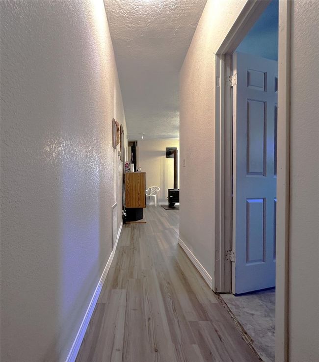 Enter the hallway to the utility room on the right and primary bedroom up ahead. | Image 26
