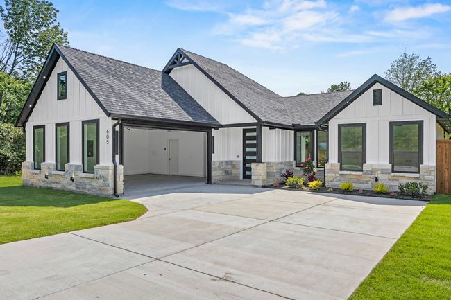 Modern inspired farmhouse featuring roof with shingles, concrete driveway, stone siding, a garage, and a front lawn | Image 5