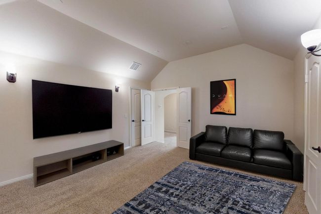Carpeted living room with lofted ceiling and baseboards | Image 14