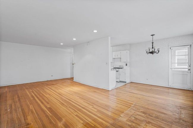 Unfurnished living room featuring a chandelier, light wood-style floors, and recessed lighting | Image 5