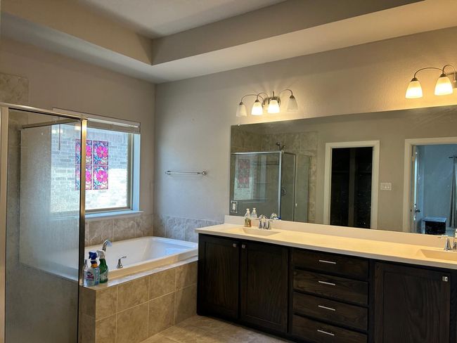 Full bathroom with a stall shower, double vanity, a garden tub, and tile patterned floors | Image 28