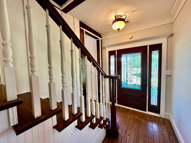 Entryway with wood-type flooring, stairs, and crown molding | Image 15