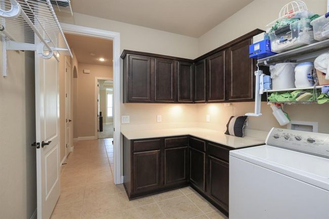 So nice to have a laundry room with upper and lower cabinets for storage. And plentry of hanging space. Door to garage. | Image 30