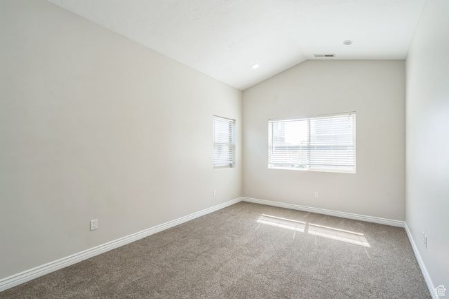 Carpeted spare room featuring lofted ceiling and baseboards | Image 29