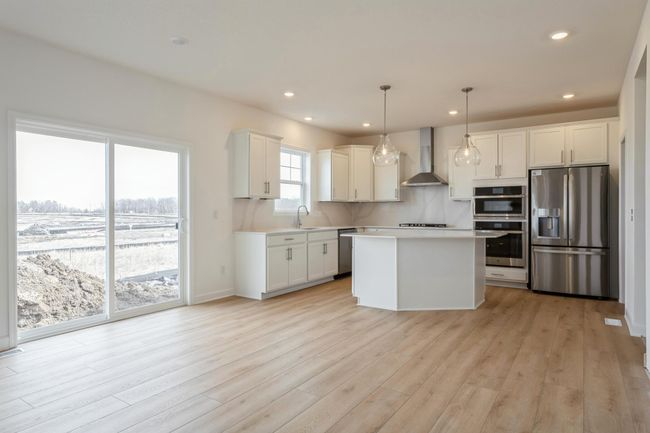 Photo is of the actual home. Soaked in natural sunlight, the homes eat-in dining room has ample space for a dining table located in the heart of the home. | Image 4