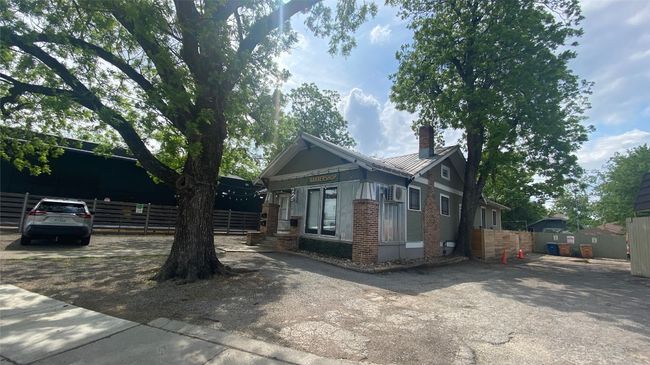 View of front of building featuring brick siding, a chimney, and a metal roof | Image 17