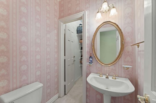 Half bathroom featuring wallpapered walls, toilet, a sink | Image 33