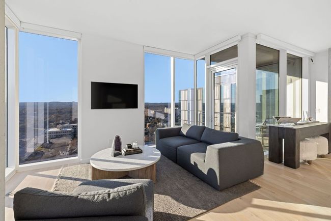 Living room with a wall of windows, wood finished floors, and a healthy amount of sunlight | Image 6