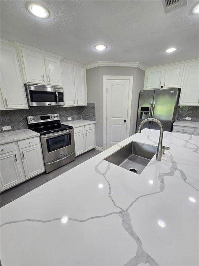 More views of the kitchen with beautiful countertops and lots of space for entertaining. | Image 8