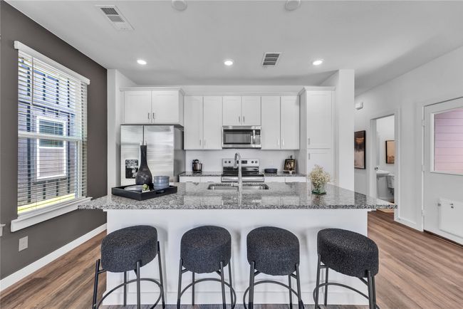 Kitchen with visible vents, stainless steel appliances, and a breakfast bar area | Image 7