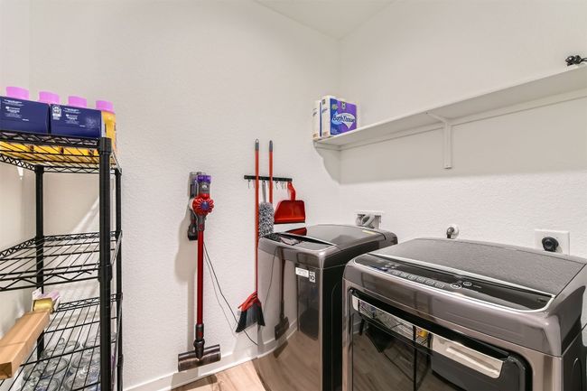 Laundry area featuring independent washer and dryer, wood finished floors, baseboards, and laundry area | Image 21