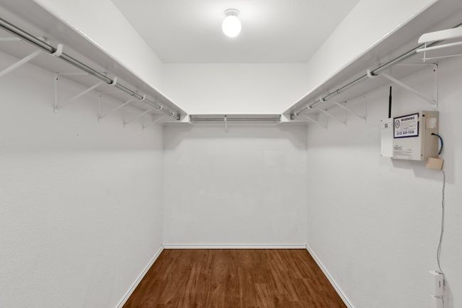 Huge walk-in primary closet with wood finished floors | Image 27