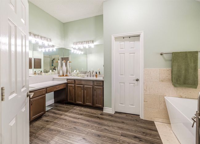 Bathroom with a soaking tub, vanity, and wood finished floors | Image 22