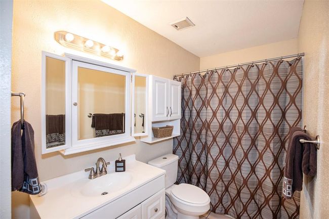 The bathroom is a bright and inviting space, featuring a sleek white vanity. A nearby linen closet provides convenient storage for towels and essentials. | Image 25