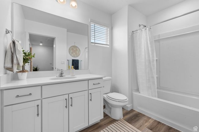 Bathroom featuring vanity, shower / bath combo, and wood finished floors | Image 13