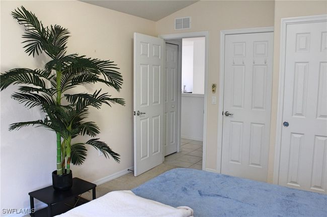 Bedroom with visible vents, vaulted ceiling, baseboards, and light tile patterned floors | Image 22