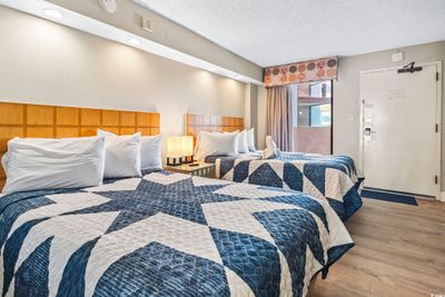 Bedroom featuring light wood-type flooring and a textured ceiling | Image 2