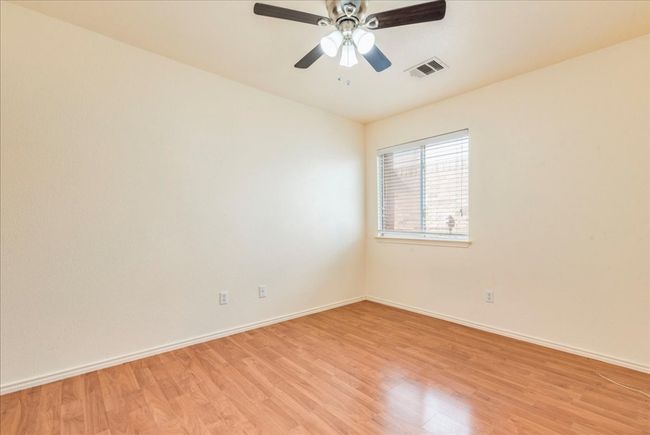 3rd guest bedroom with light wood-style floors, baseboards, and a ceiling fan | Image 14