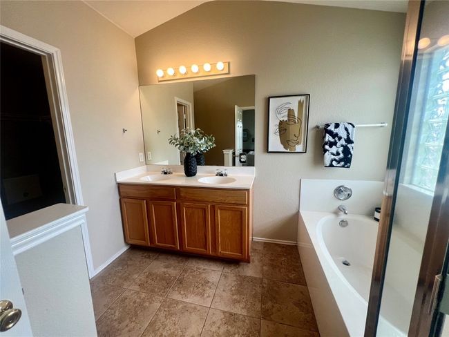 Full bath with double vanity, vaulted ceiling, and a garden tub | Image 21