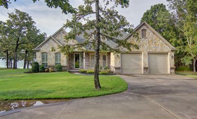 View of front facade with a garage and a front lawn | Image 1