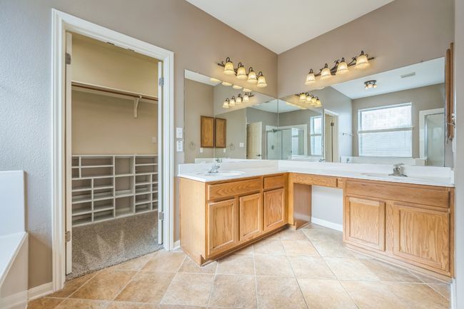 Bathroom featuring double vanity, a spacious closet, a stall shower, and a sink | Image 16