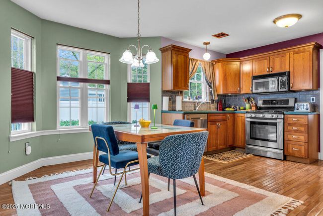 Cherry Cabinets by "Kraftsmaid" design in kitchen and Cherry hardwood flooring. | Image 12