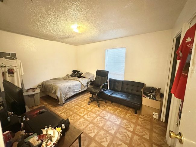 Bedroom featuring a textured ceiling and light flooring | Image 12