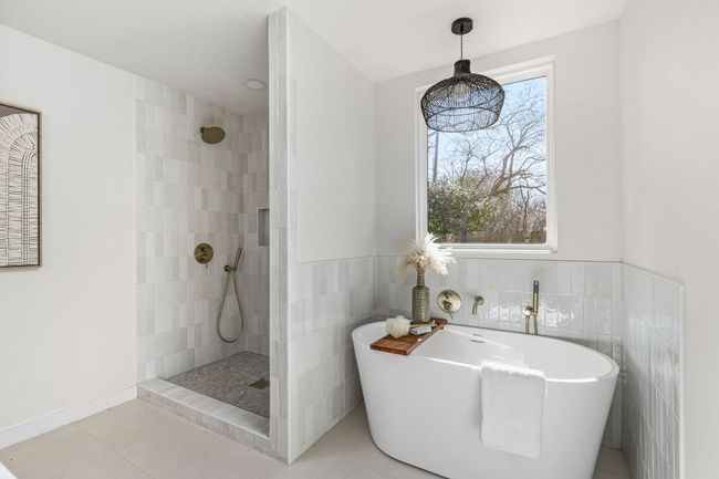Full bathroom with a walk in shower, a soaking tub, tile patterned flooring, and tile walls | Image 27